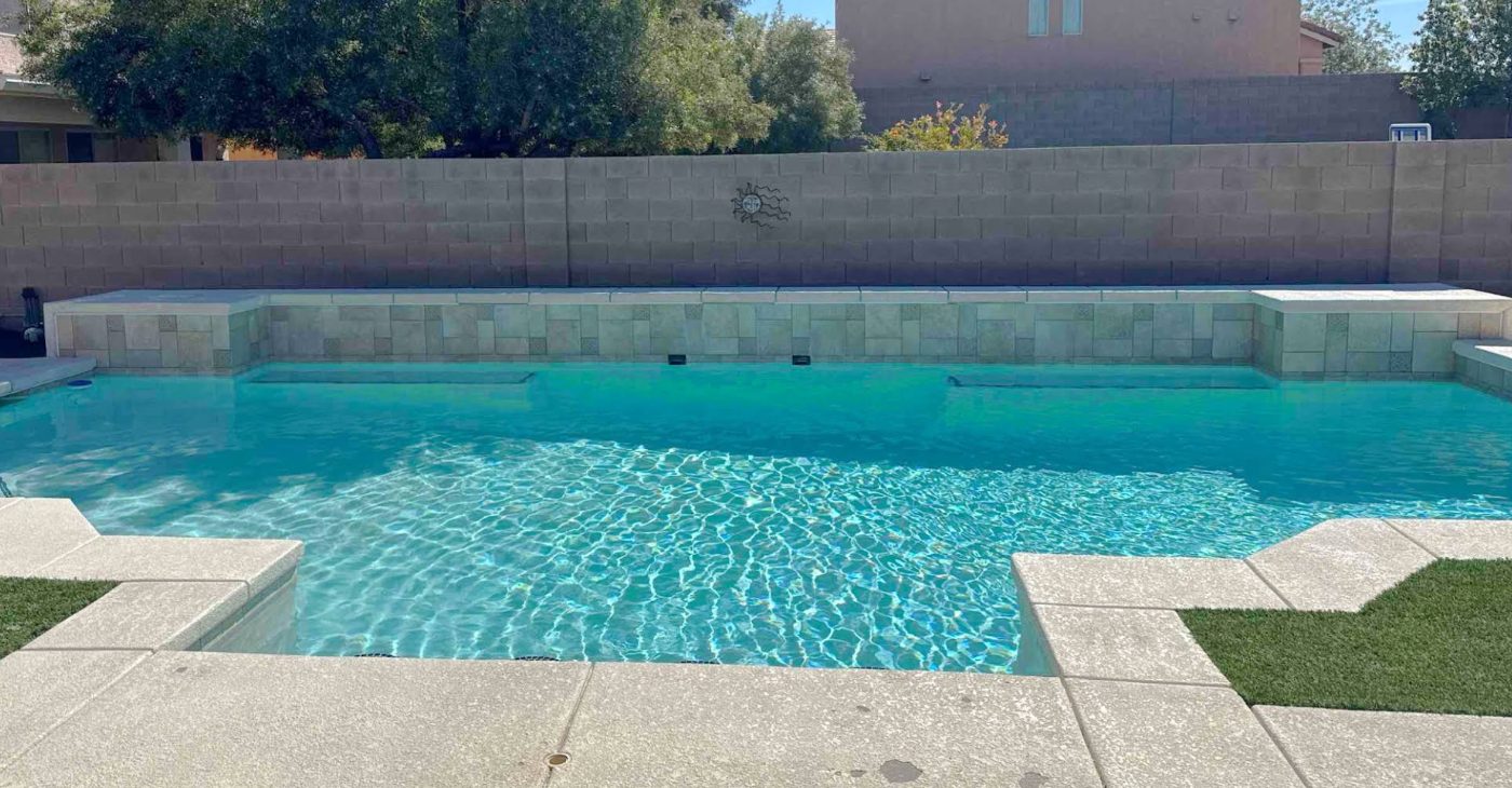 Clear blue backyard pool with tile raised wall in Henderson, serviced by Summit Pool Services